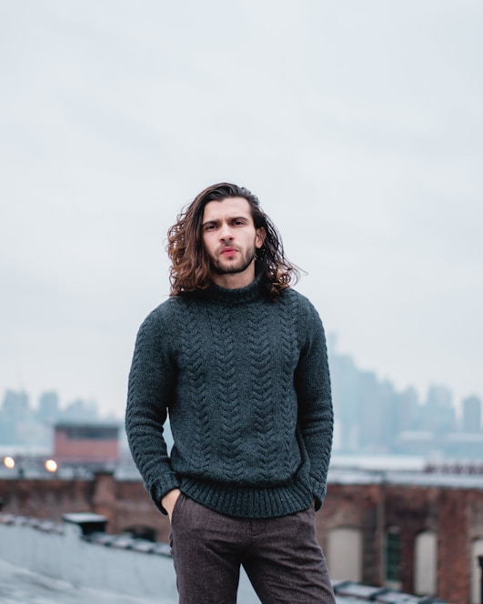 woman in gray sweater standing on brown wooden dock during daytime