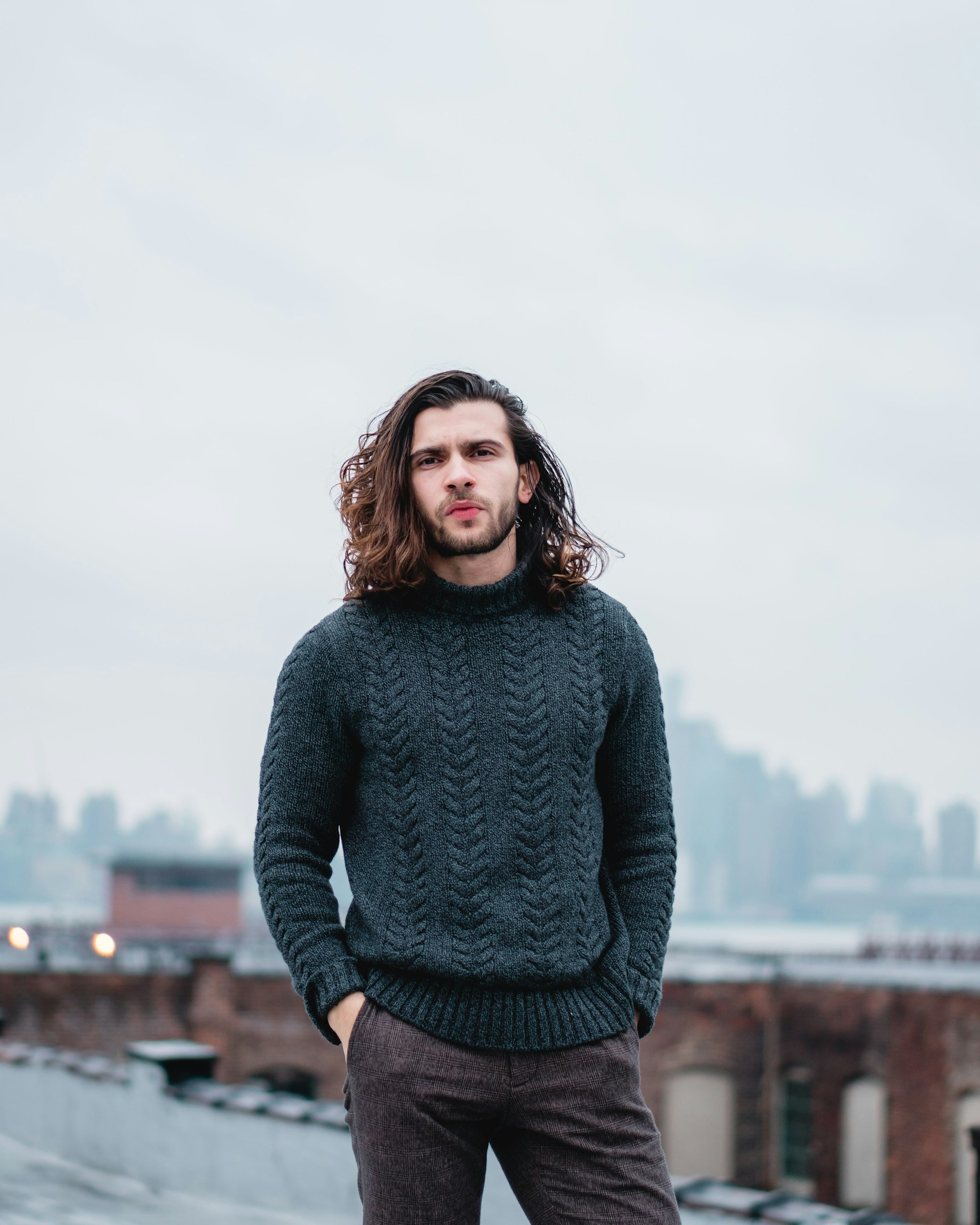 woman in gray sweater standing on brown wooden dock during daytime