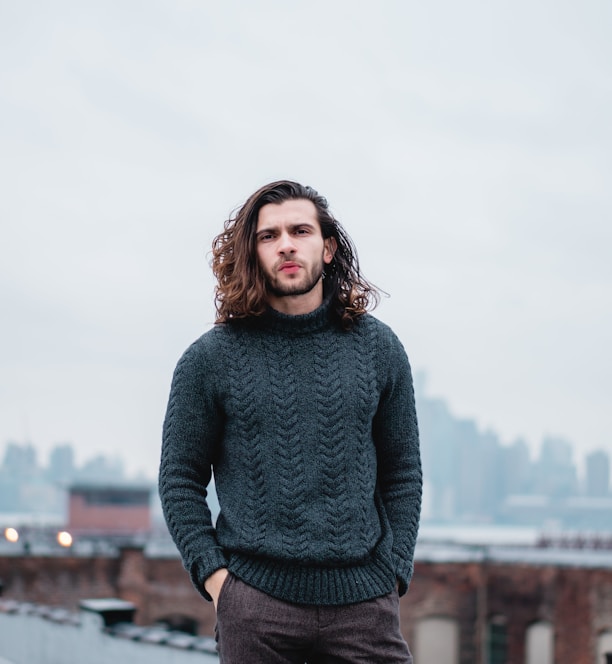 woman in gray sweater standing on brown wooden dock during daytime