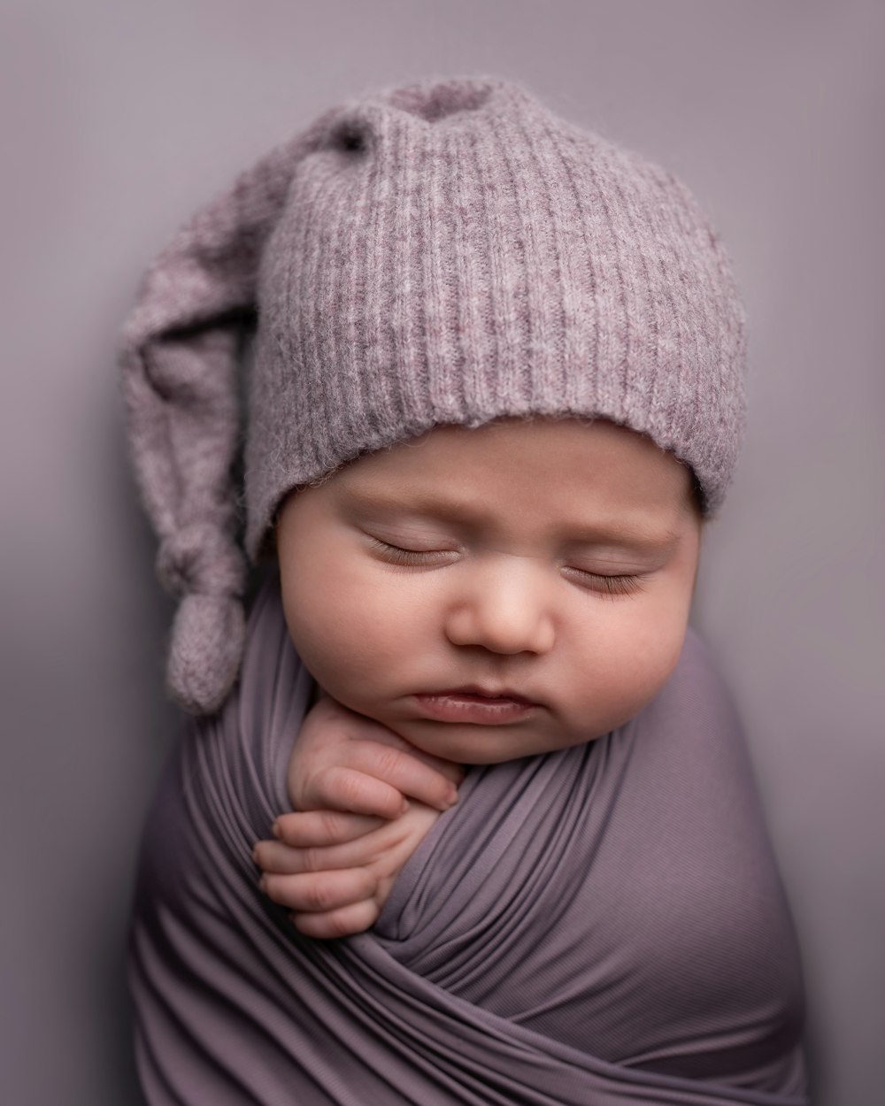 Bambino in berretto grigio in maglia