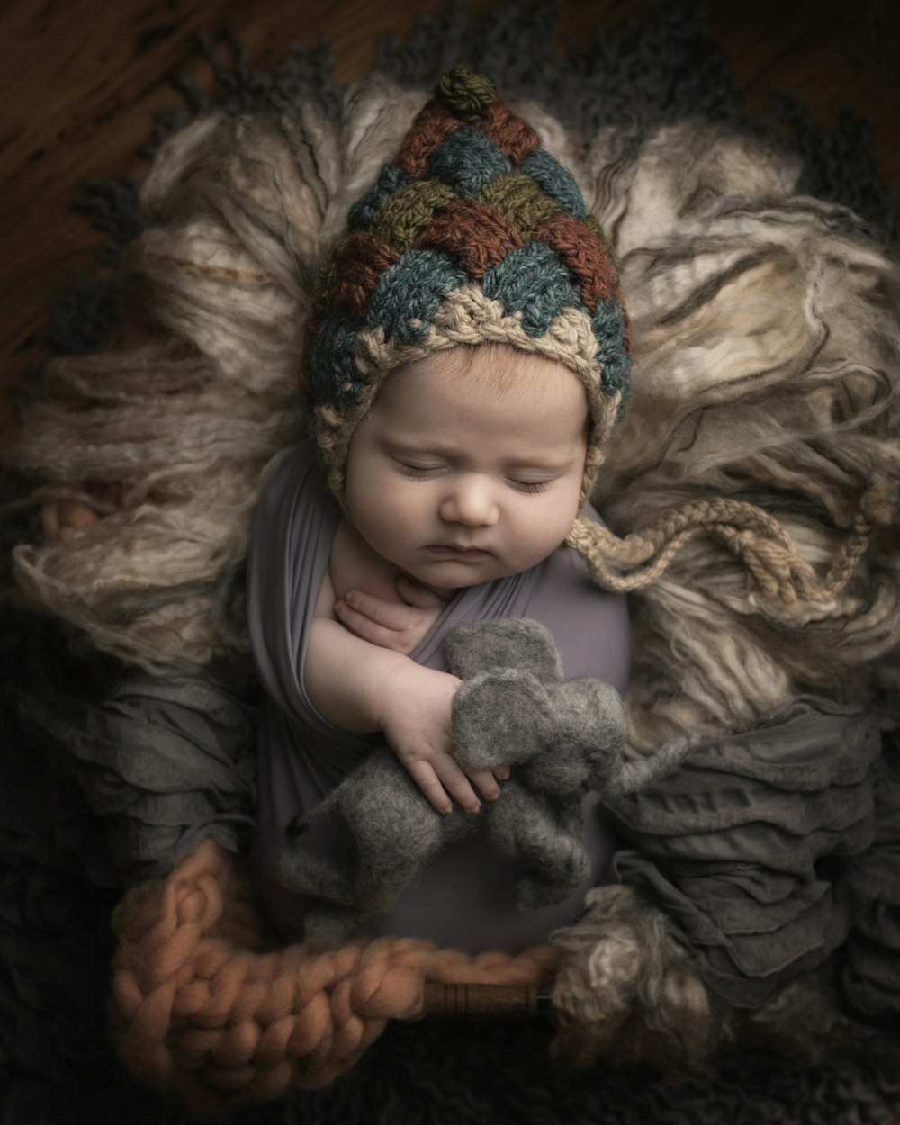 girl in grey long sleeve shirt lying on grey fur textile