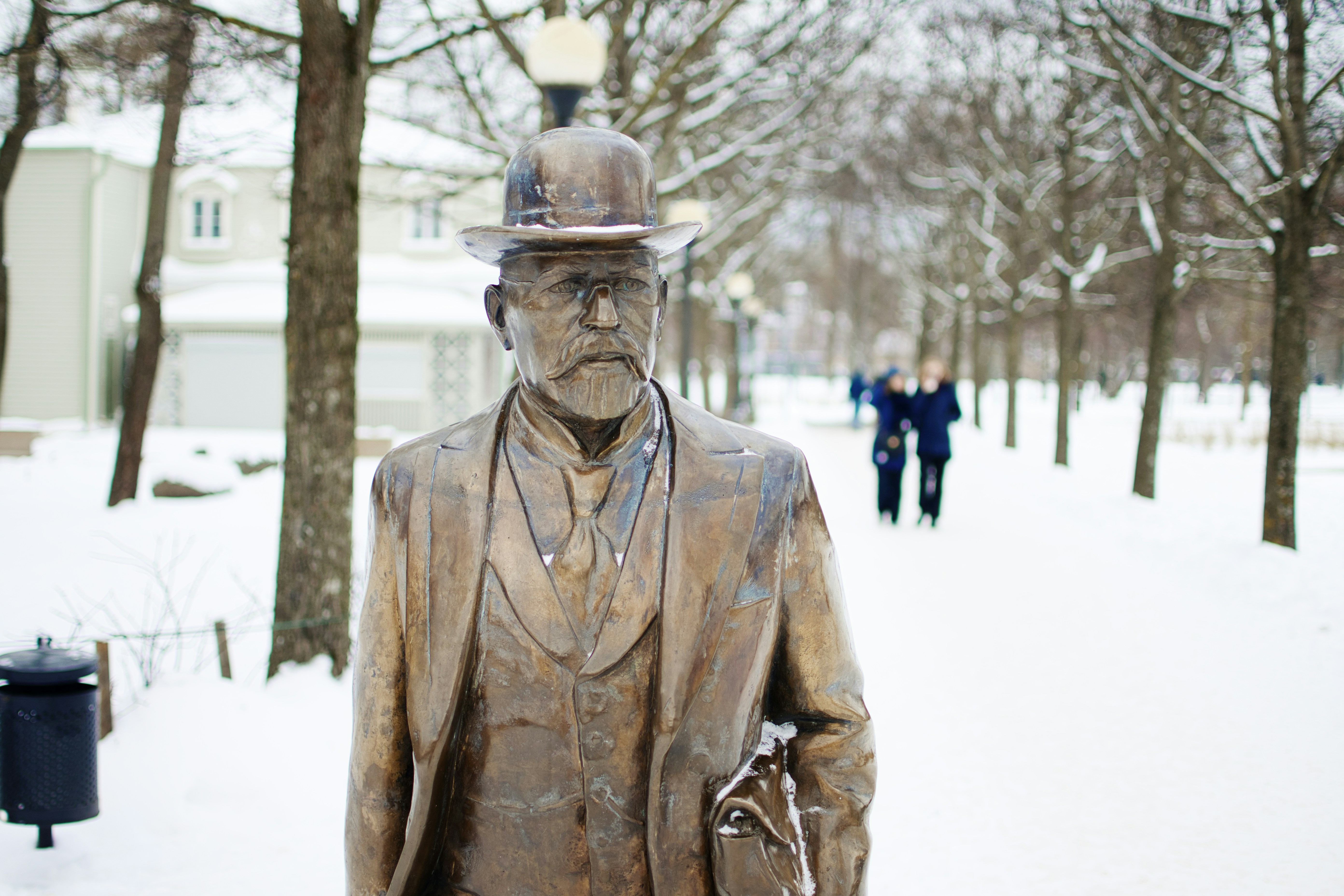 man in brown leather coat statue during daytime, Statue in snow