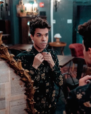 Artisan fitting a decorative mirror frame in a cozy living room setting.