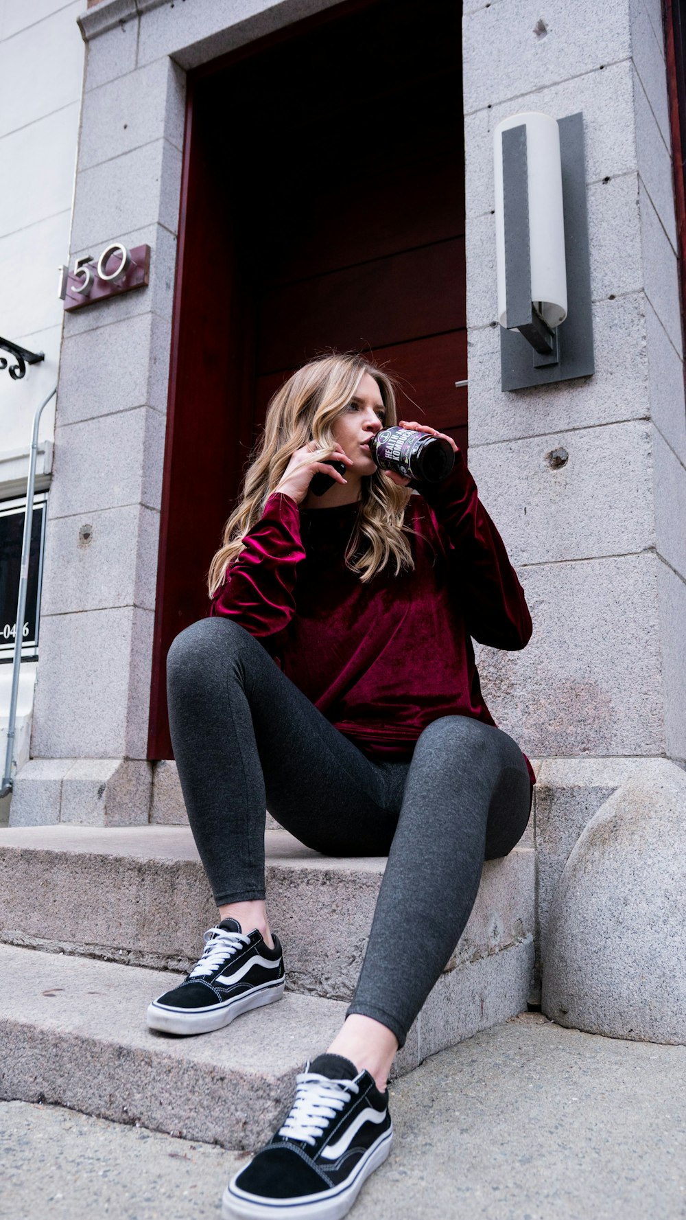 woman in red long sleeve shirt and gray pants sitting on gray concrete  stairs photo – Free Black Image on Unsplash