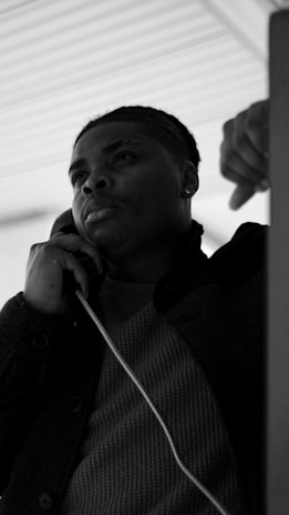 man in black jacket holding his chin