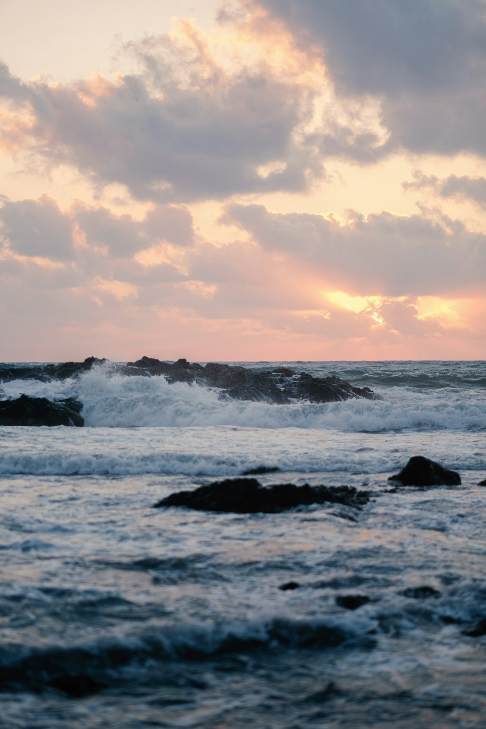 Les vagues de l’océan s’écrasent sur les rochers au coucher du soleil