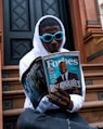 man in white long sleeve shirt holding magazine