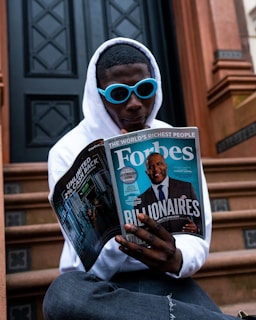 man in white long sleeve shirt holding magazine