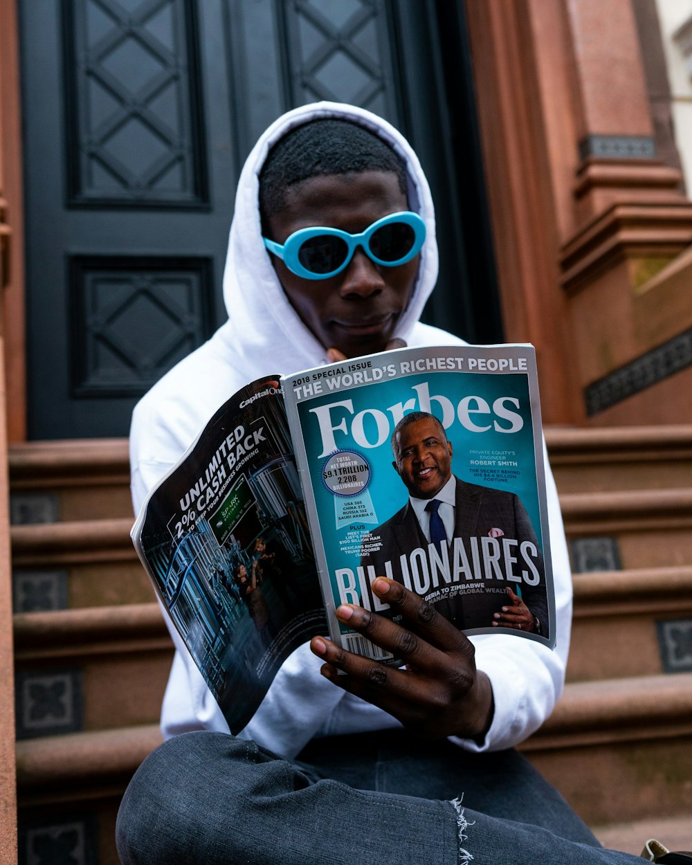 man in white long sleeve shirt holding magazine