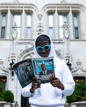man in white thobe holding newspaper