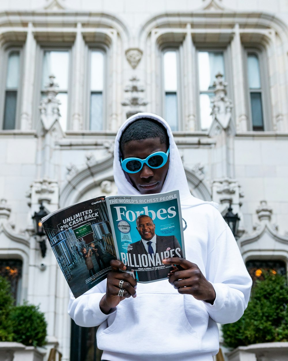 man in white thobe holding newspaper