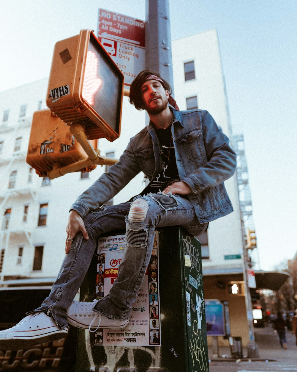 man in blue denim jacket and blue denim jeans sitting on orange plastic crate