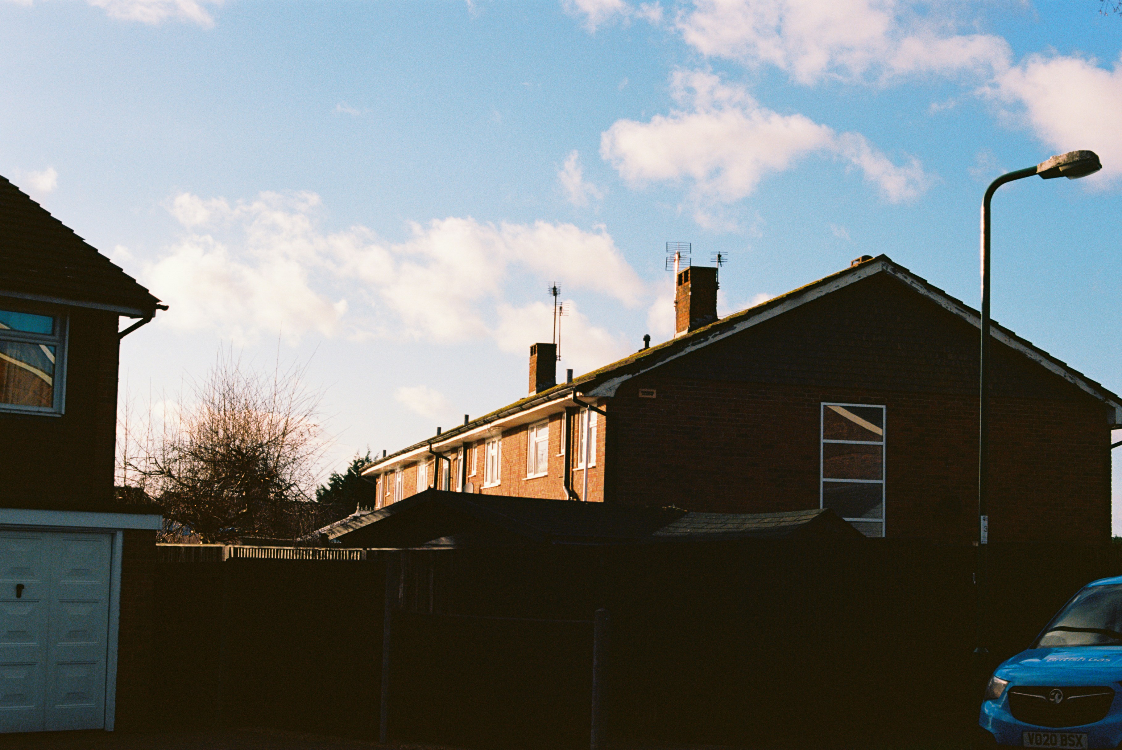 White and brown wooden house near bare trees under blue sky during ...