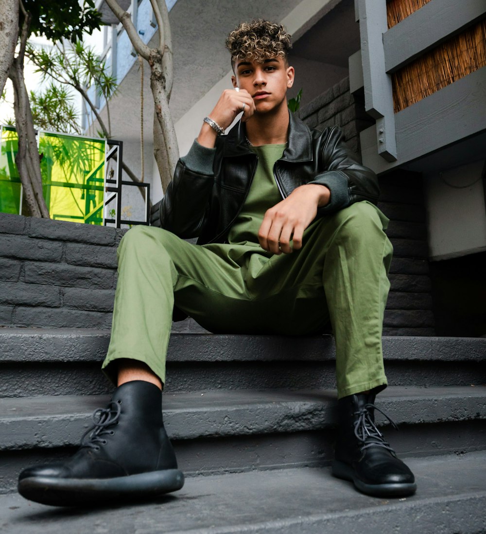 Homme en pantalon vert et veste en cuir noir assis sur des escaliers en  béton gris photo – Photo La personne Gratuite sur Unsplash