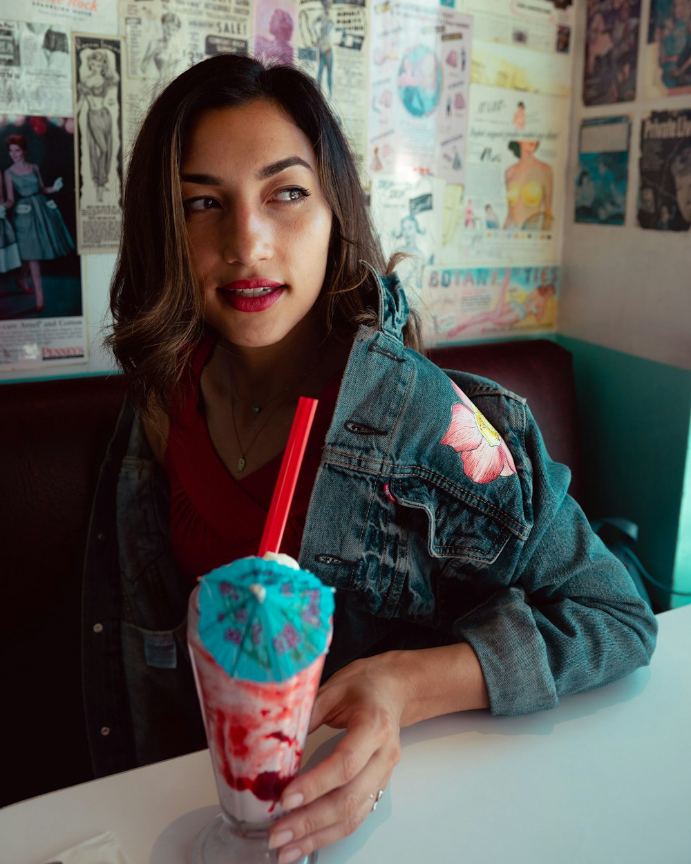 woman in blue denim jacket holding strawberry ice cream