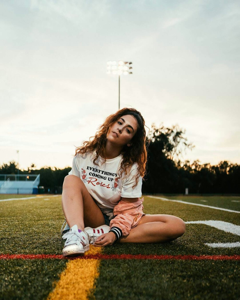 woman in white crew neck t-shirt sitting on the ground