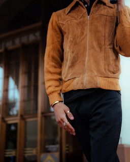 man in brown zip up jacket and black pants