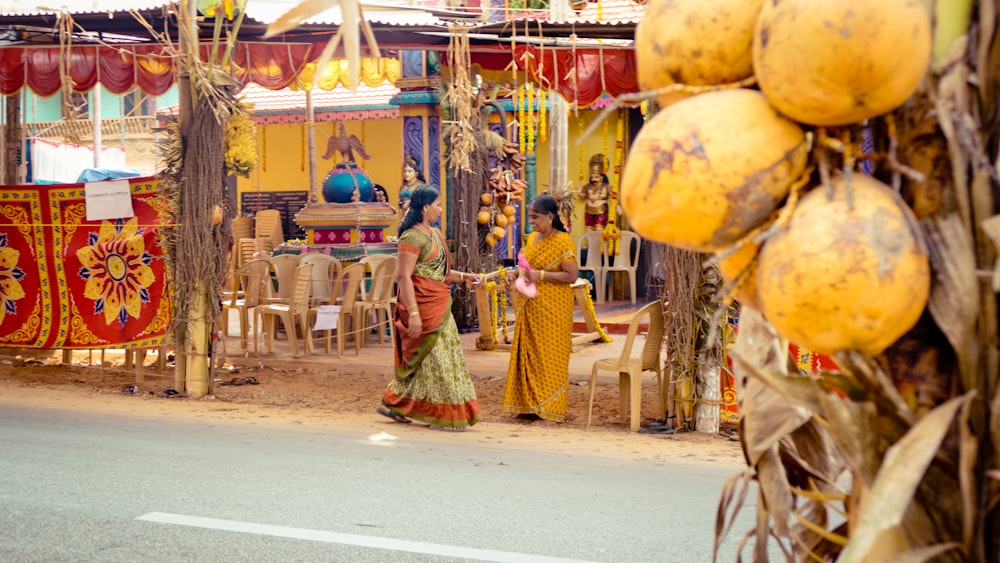 woman in yellow and red dress standing near yellow and red balloons during daytime