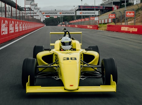 yellow and black f 1 car on road during daytime