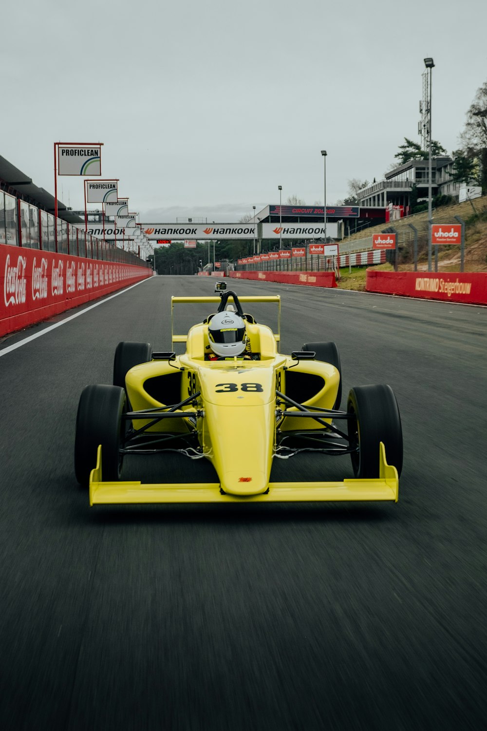 Coche F 1 amarillo y negro en la carretera durante el día