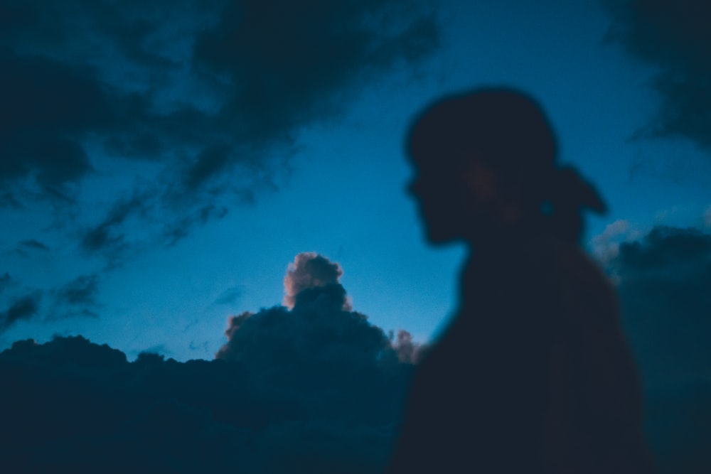 silhouette of man under blue and white cloudy sky