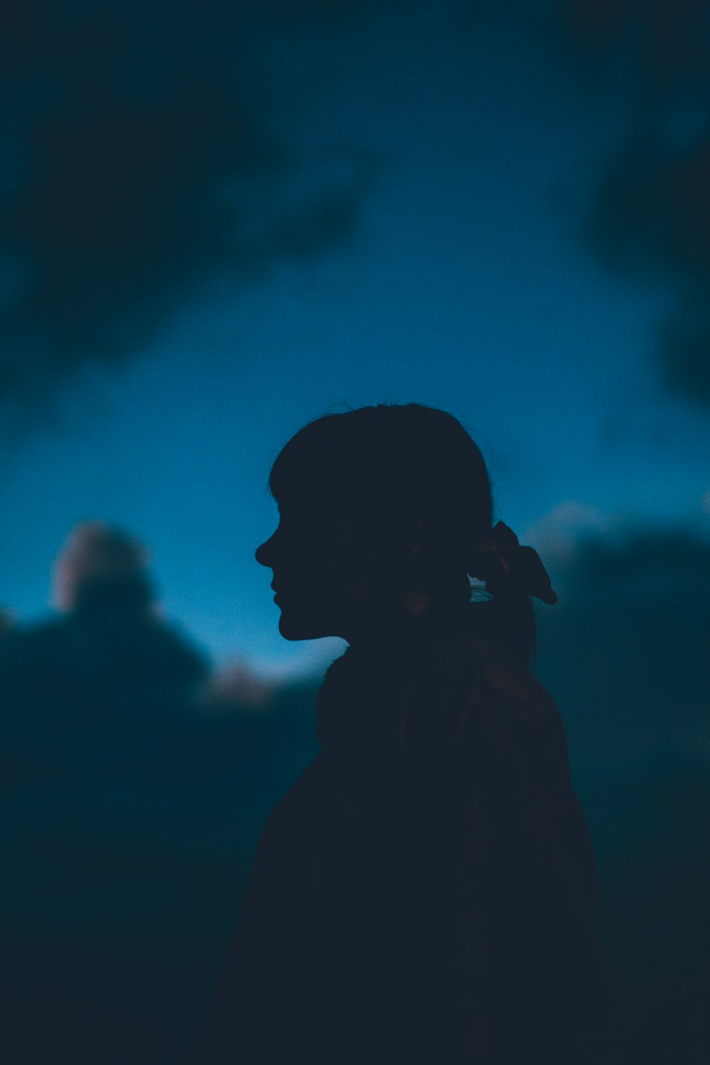 silhouette of man with blue light in the background