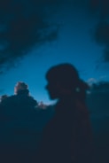 Silhouetted figure against a stormy night sky, evoking mystery and longing.