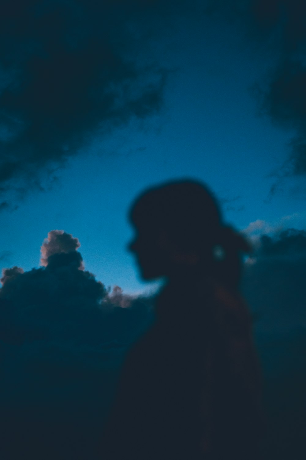 Silhouette de l’homme sous un ciel nuageux bleu et blanc