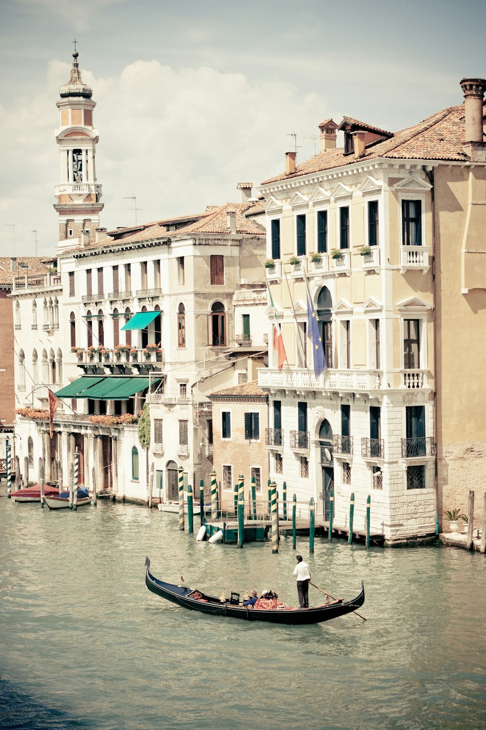 people riding on boat on river near concrete buildings during daytime