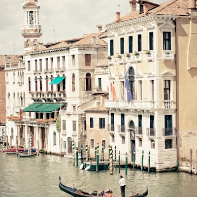 people riding on boat on river near concrete buildings during daytime