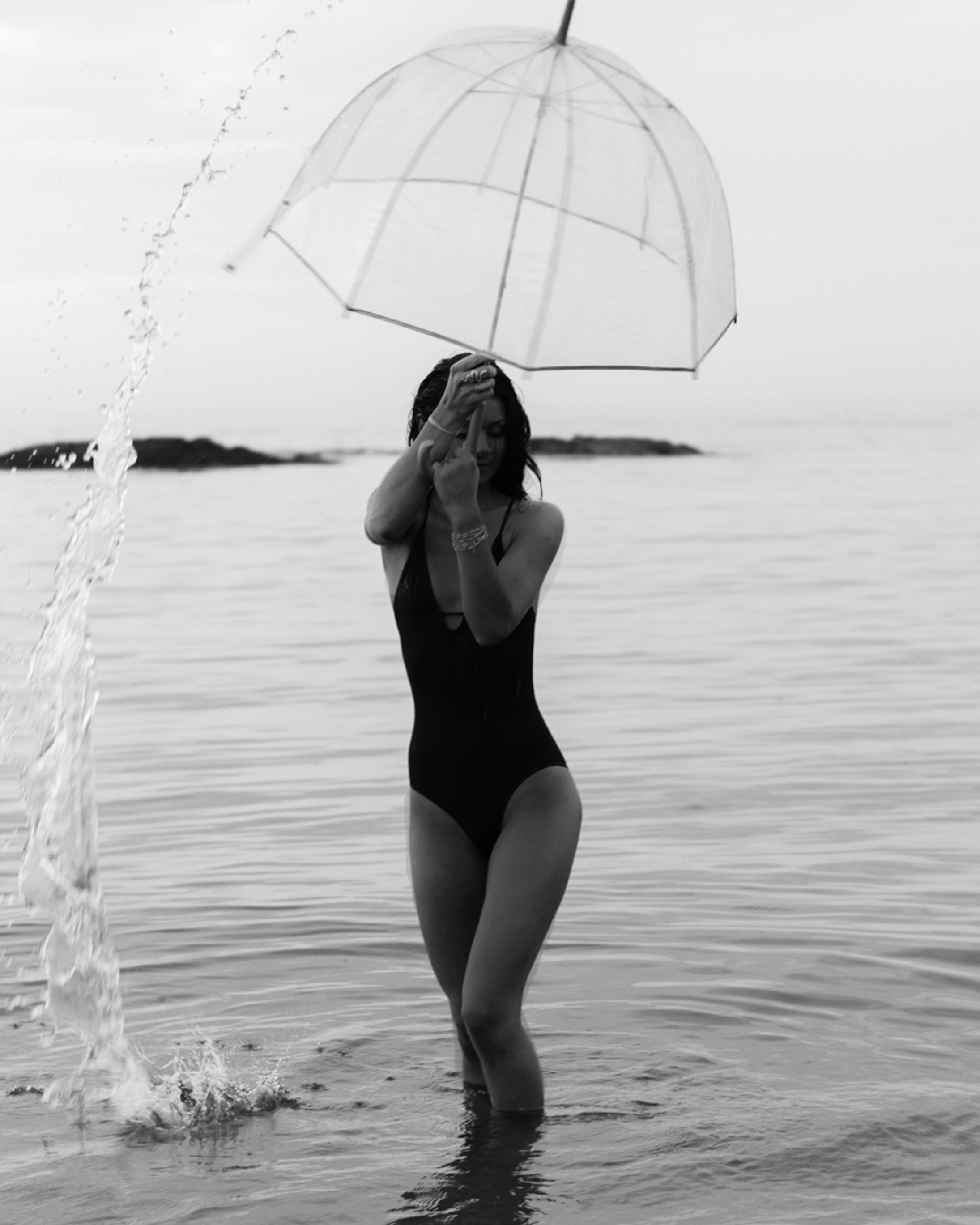 水の中で傘を保持している黒のワンピース水着の女性の写真 Unsplashで見つける黒の無料写真