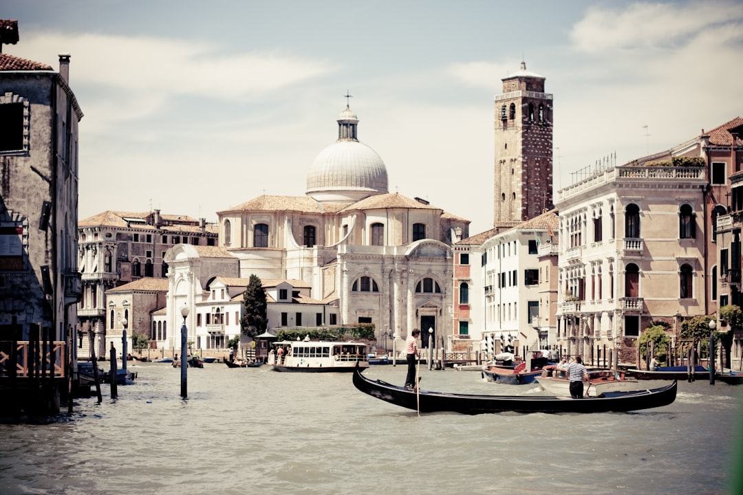 people riding on boat on river near buildings during daytime