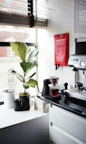 red and silver coffee maker beside white ceramic mug