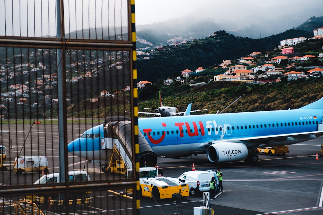 white and blue airplane on airport during daytime