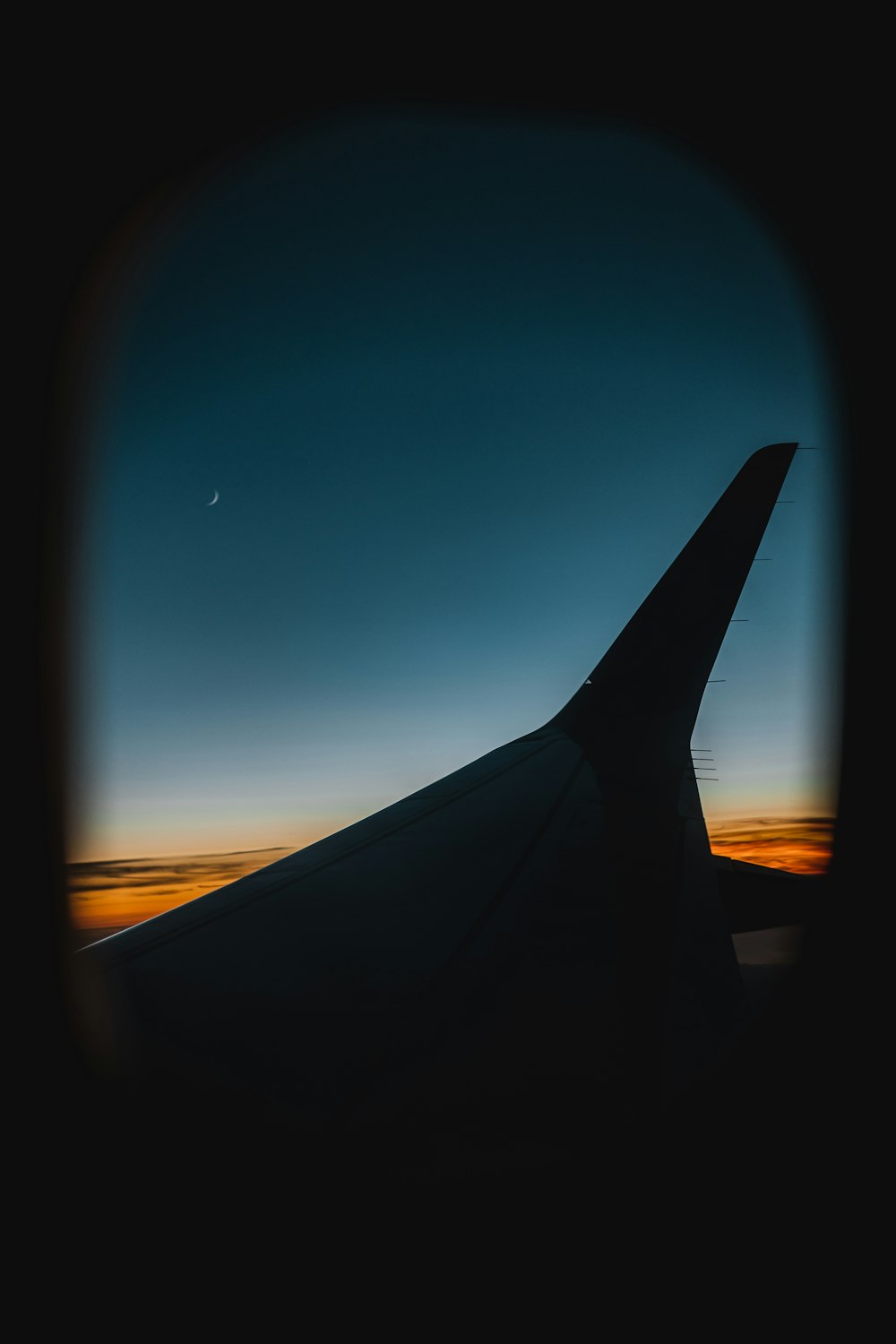 airplane wing over the clouds during night time