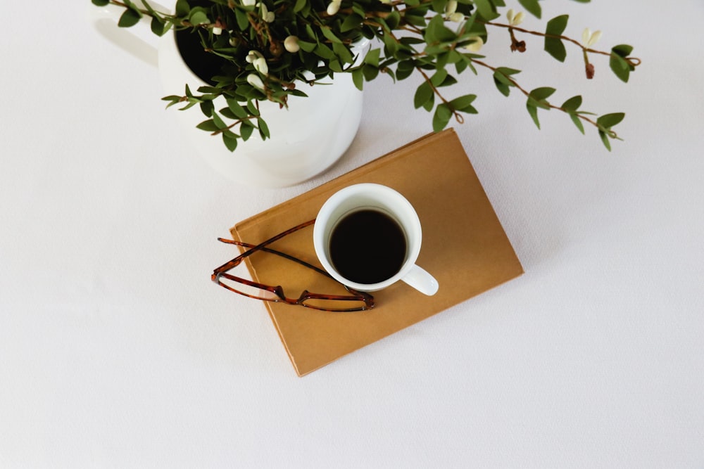 white ceramic mug with coffee on brown wooden table