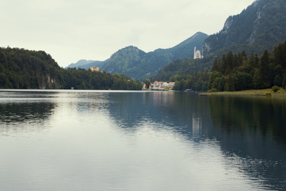 body of water near green trees and mountain during daytime