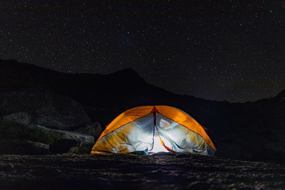 yellow tent on brown soil during night time