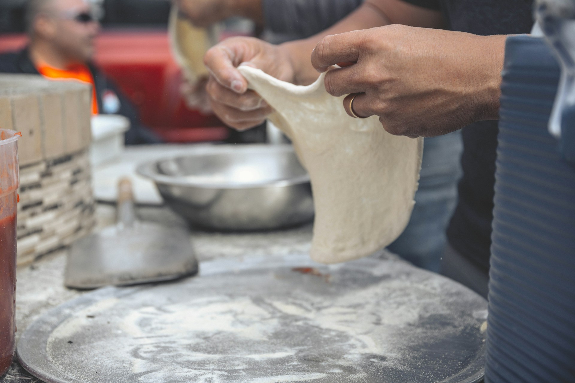 A close-up of Guilherme Santos expertly tossing pizza dough, highlighting his dedication and passion for the craft.