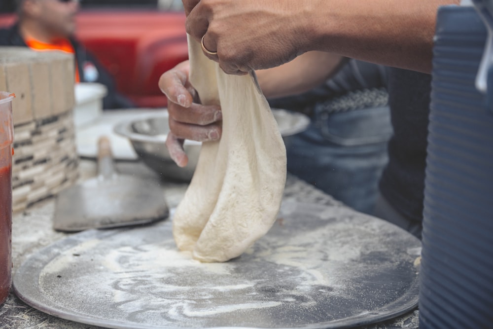 person holding white textile on stainless steel tray