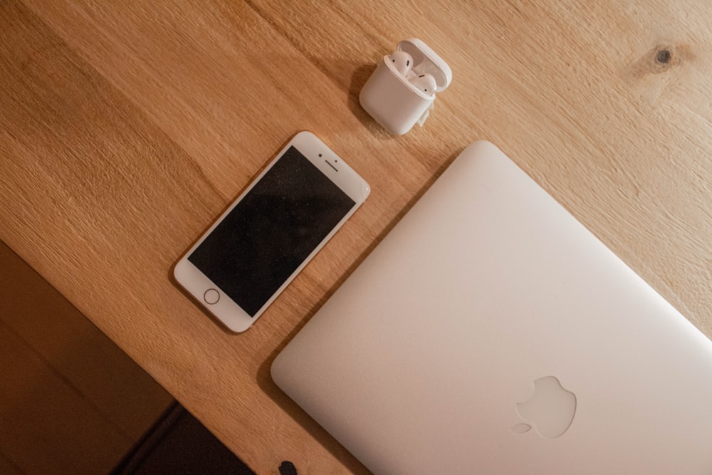 silver macbook beside white ceramic mug on brown wooden table