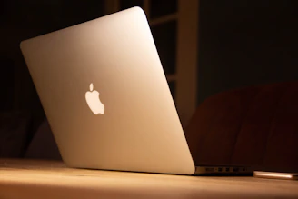 A sleek silver laptop resting on a clean white desk with soft natural light.