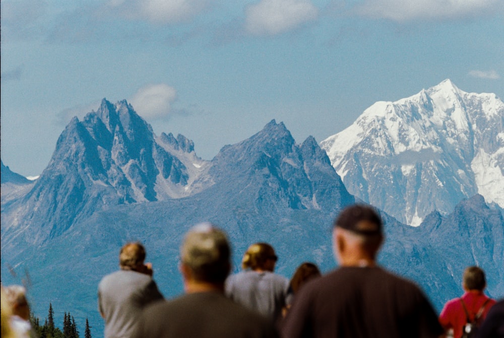 people standing near snow covered mountain during daytime