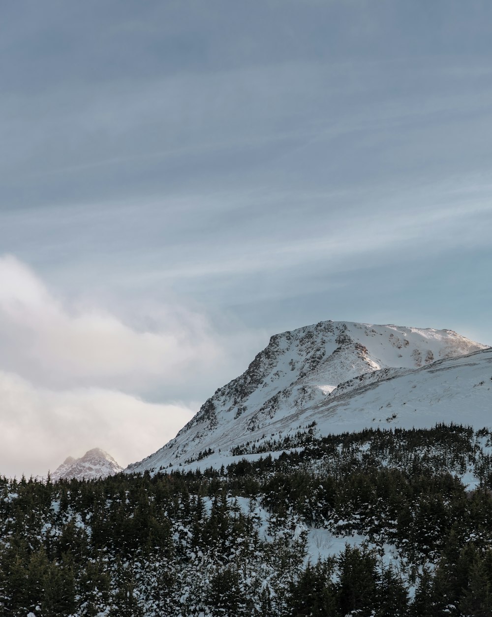 snow covered mountain under cloudy sky during daytime