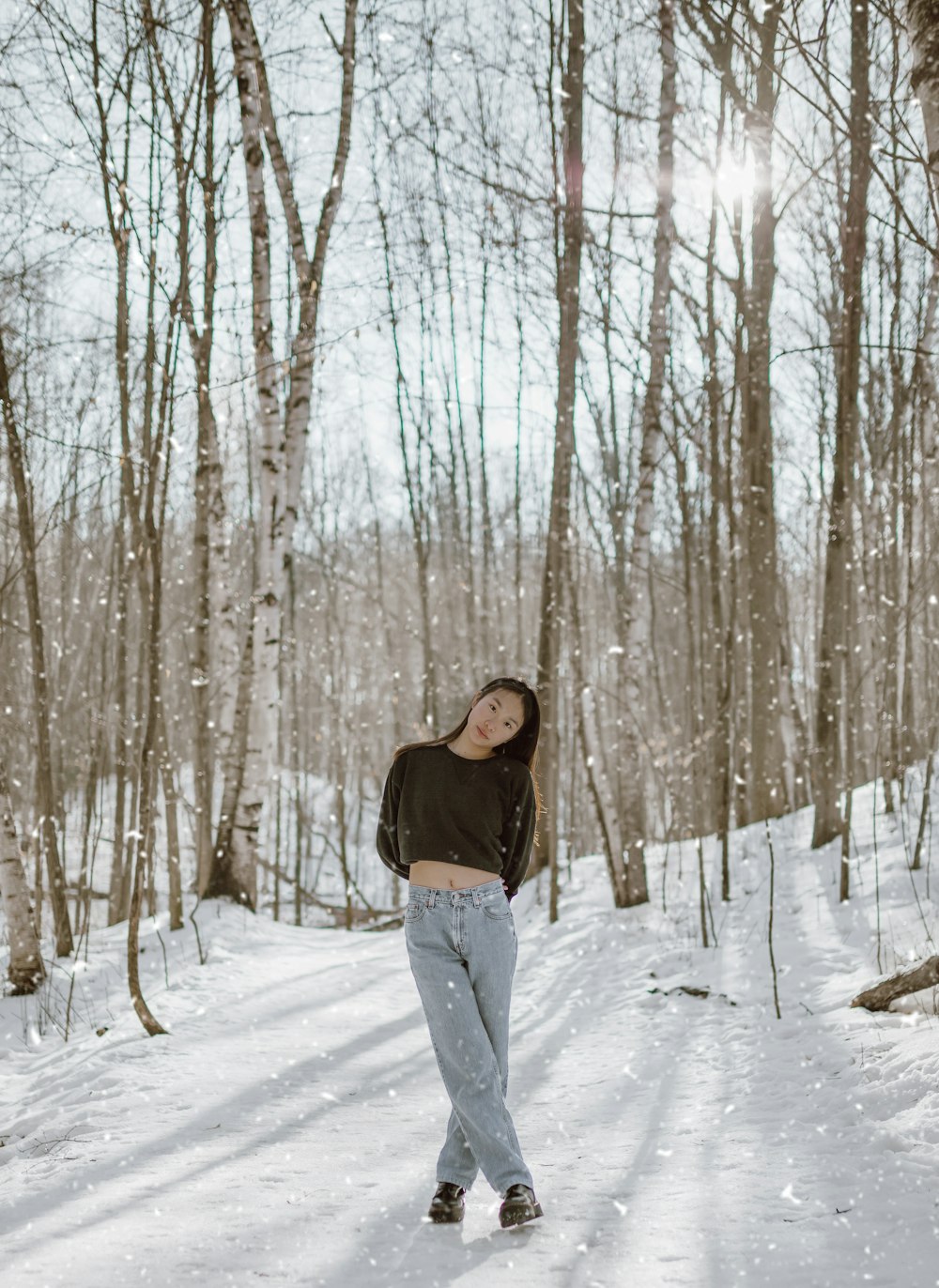 woman in black jacket standing on snow covered ground during daytime