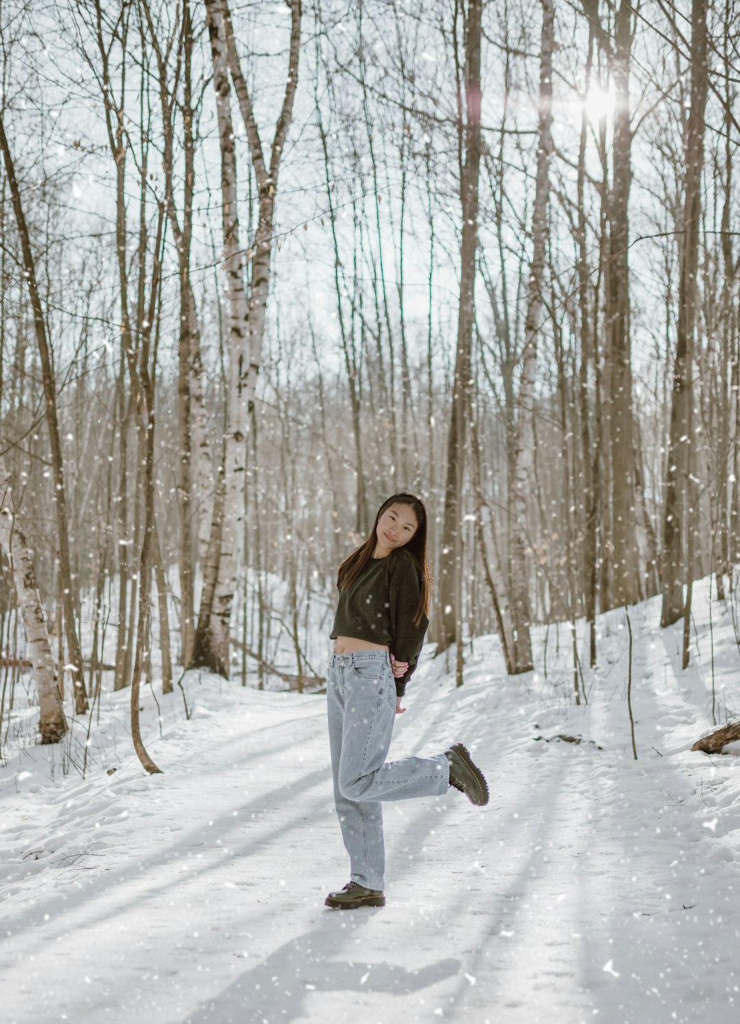 woman in black jacket and gray pants standing on snow covered ground