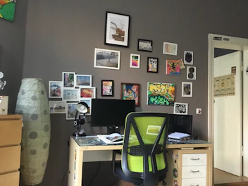 A cozy office space with a desk and comfortable chair, set against a backdrop of beach-themed artwork.