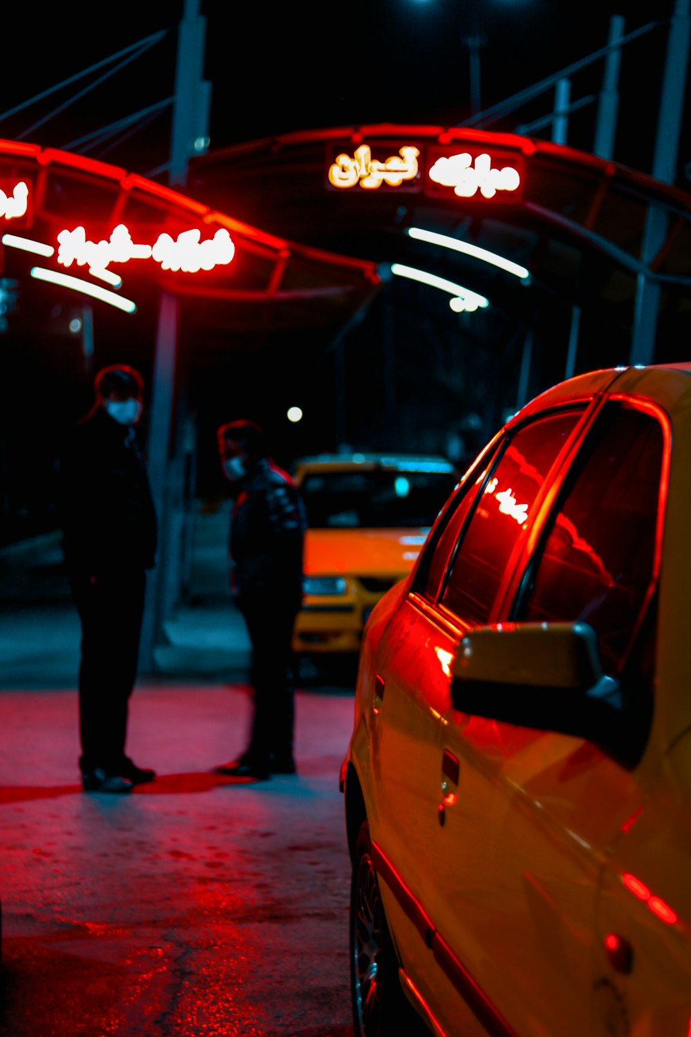 man in black jacket walking on sidewalk during night time