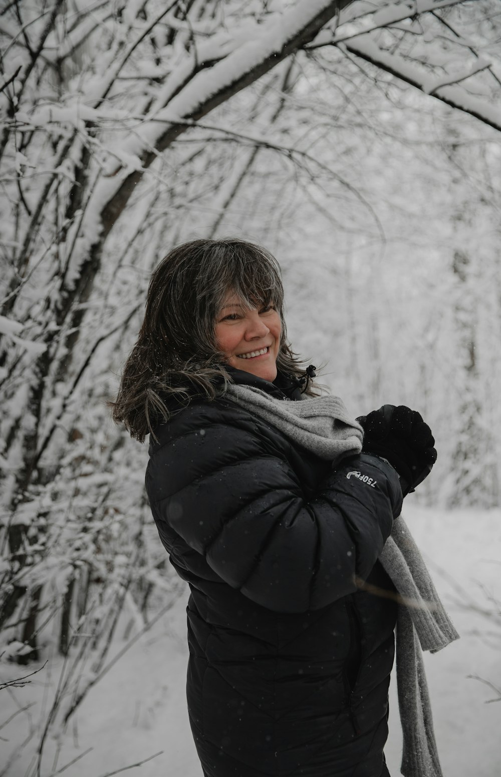 woman in black jacket standing near trees during daytime