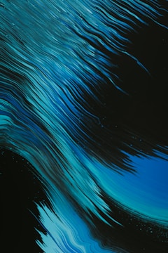Dynamic, flowing lines in various shades of blue on a dark background create a sense of movement. The lines resemble flowing water or waves, giving an abstract and energetic feel.